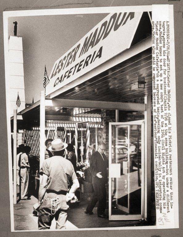 Black-and-white photo of the exterior of "Lester Maddox Cafeteria," with people standing outside. Lester Maddox, who closed his Pickrick Restaurant rather than integrate, opened for business again at the same building, but under a different name, on September 26, 1964.