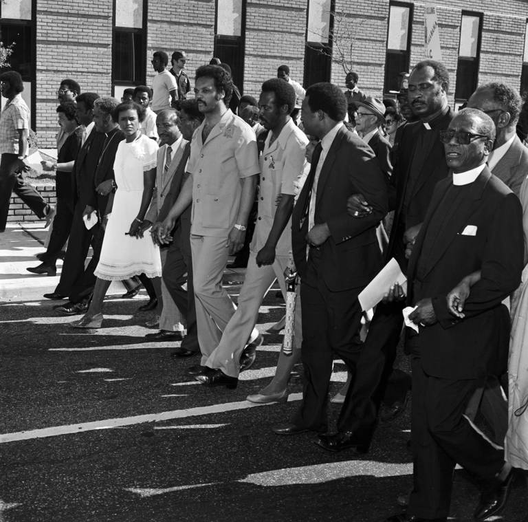 Black-and-white photo of civil rights leaders marching in Mobile, Alabama, to support the reauthorization and extension of the Voting Rights Act.