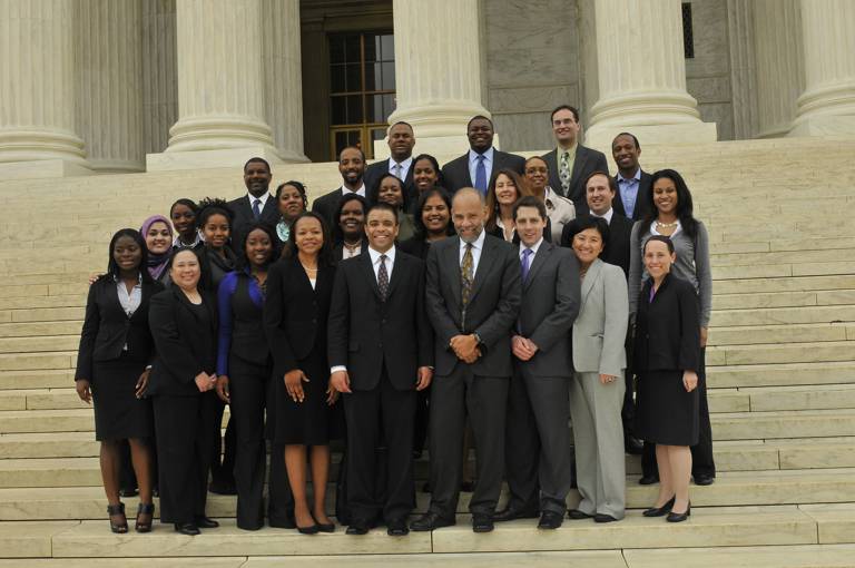 Color photo of former LDF President and Director-Counsel John Payton standing with the LDF litigation team on the Supreme Court steps.