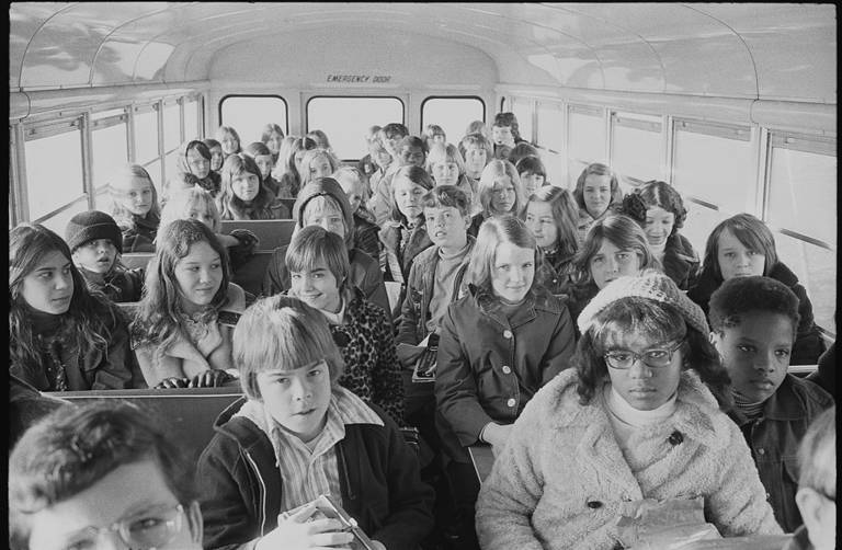 Black-and-white photo of Black and white students riding inside a school bus on their way from the suburbs to an inner-city school in Charlotte, North Carolina, on February 21, 1973.