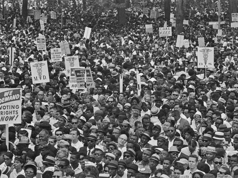 Black-and-white photo of a large crowd of demonstrators, some holding placards, at the March on Washington for Jobs and Freedom in Washington, D.C., on August 28, 1963.