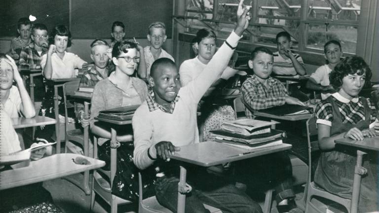 Black student raises hand in integrated classroom.