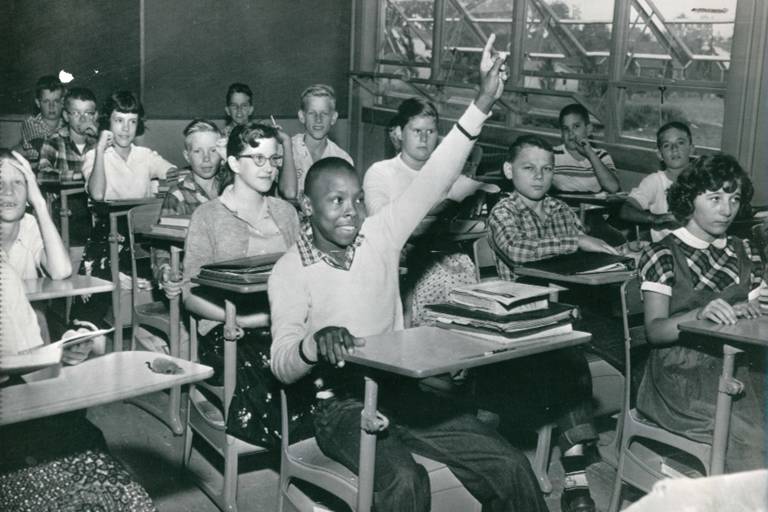 Black student raises hand in integrated classroom.