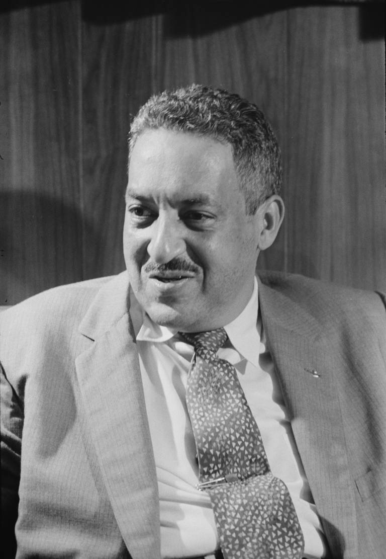 Black-and-white photo of Thurgood Marshall in a suit and tie looking away from center of photo.