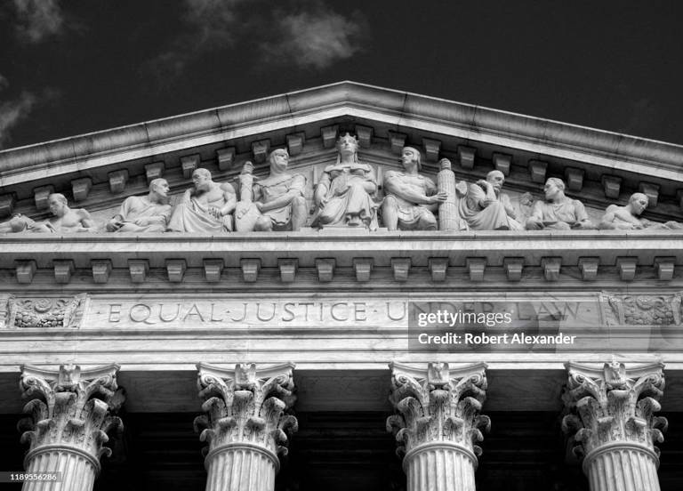 Black-and-white photo of the top of the Supreme Court building, with engraved text reading, "Equal justice under law."