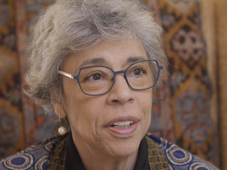 Color photo of Gabrielle Kirk McDonald, seated indoors and wearing glasses, during her oral history interview.