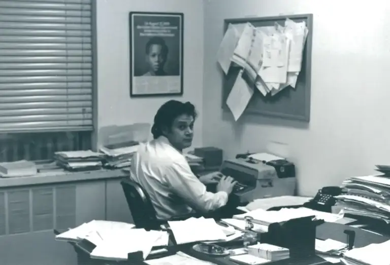 Black-and-white photo of Melvyn Leventhal sitting at his desk typing on a typewriter.