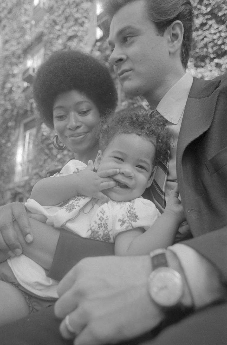 Black-and-white photo of Alice Walker and Melvyn Leventhal holding their young, smiling daughter, Rebecca.