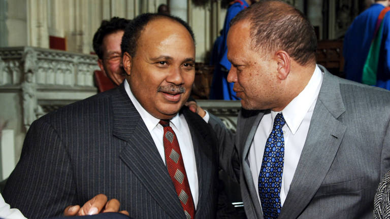 Color photo of Martin Luther King III and Ted Shaw, both wearing suits, speaking to each other.