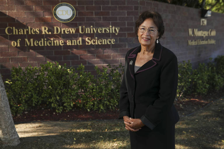 Color photo of Sylvia Drew Ivie standing outside the Charles R. Drew University of Medicine and Science building.