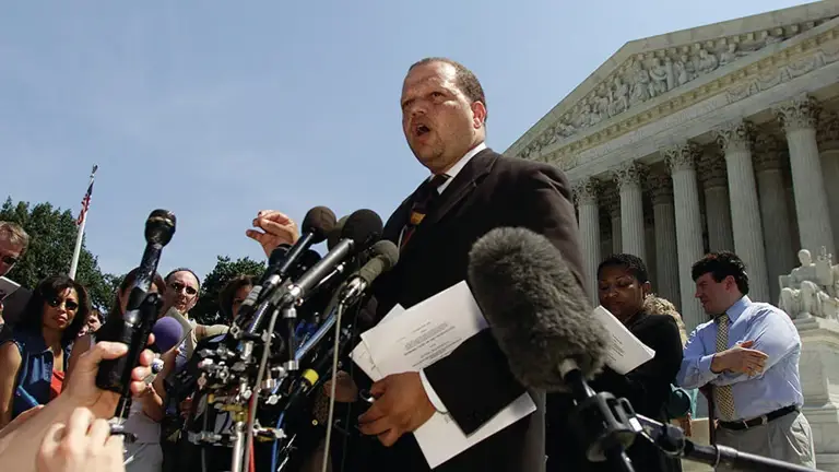 Color photo of Ted Shaw speaking to media outdoors in South Carolina, in front of a courthouse.