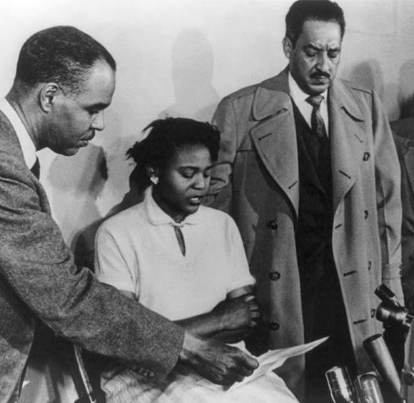 Photo of American civil rights activist Autherine Lucy, seated at a press conference at the NAACP's national office in New York on March 2, 1956. Lucy was the first Black student to attend the University of Alabama, but was suspended after anti-integration riots broke out on campus. With her are NAACP director Roy Wilkins (left) and LDF Director-Counsel Thurgood Marshall (right).