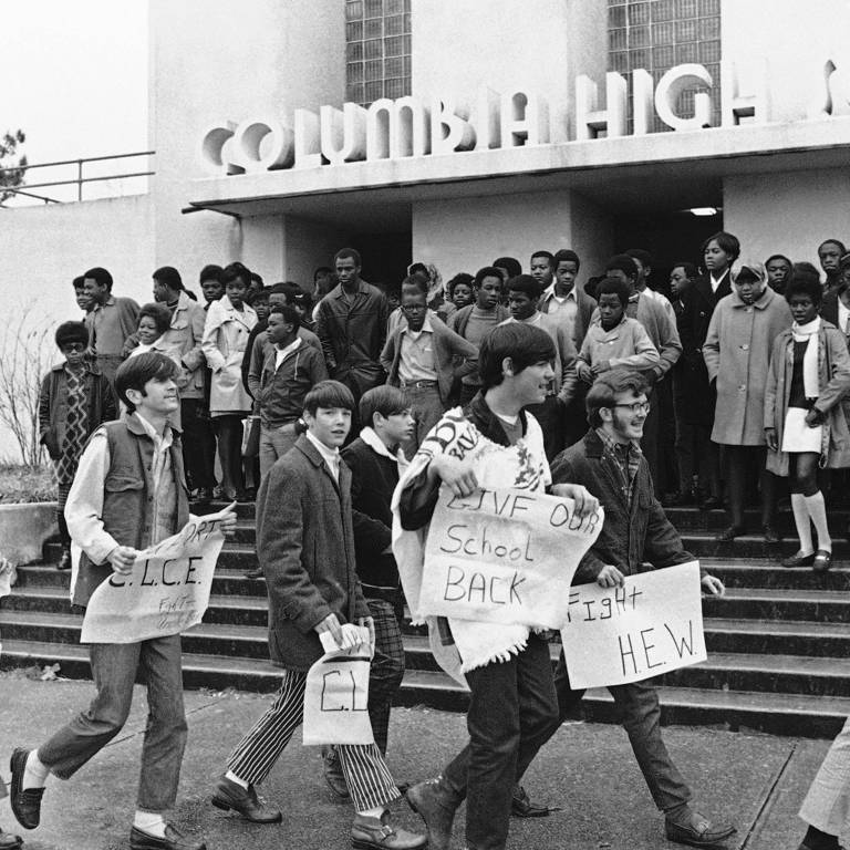 Boycotting white students walking outside Columbia High School in Mississippi while Black students wait to attend classes.